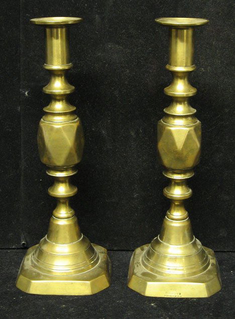 Pair of brass push-up candlesticks, 19th c., Mark: Pair of brass push-up candlesticks 19th c. Marked: The Diamond Princess, English". Cast shaft on square base. H: 10 7/8 in. PROVENANCE: From the collection of Marie Evans, Alexandria, Virginia"