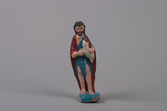 An Ecuadorian Polychrome Painted and Carved Wood: carrying a lamb.Height 8 inches.