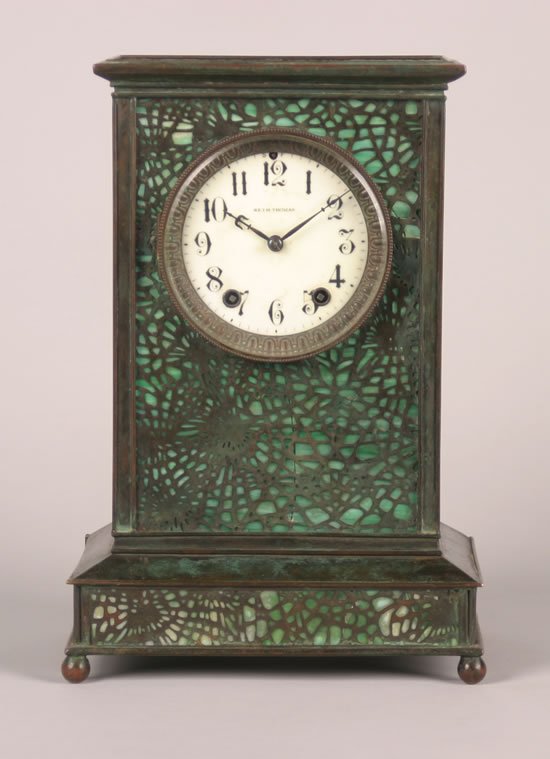 A Glass and Bronze Overlay Mantle Clock,: "in the style of Tiffany, probably by Apollo Studios, with spurious signature for Tiffany Studios.Height 13 x width 9 x depth 6 inches."