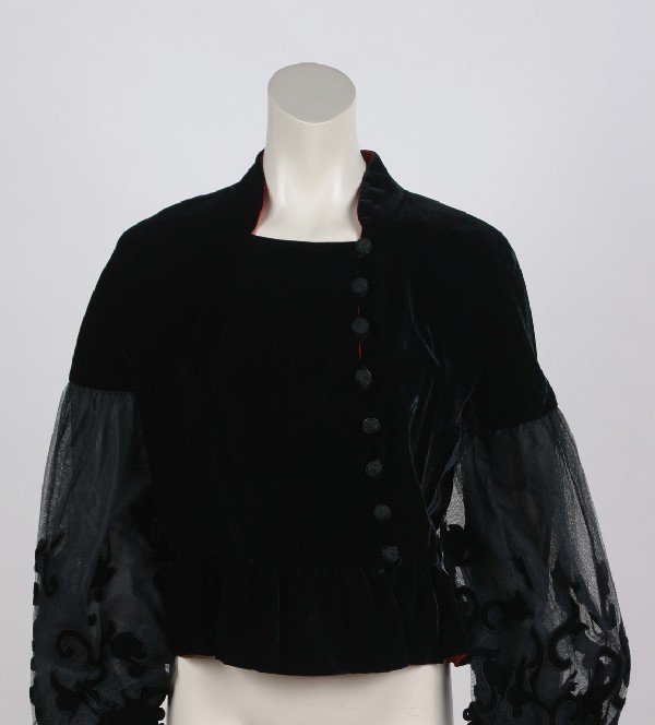A Karl Lagerfeld Black Velvet Jacket, Size 44.: A Karl Lagerfeld Black Velvet Jacket, 1980s, jacket buttons left of center with circular corded buttons, hem has slight flounce on hip, mandarin collar lined in red. Shear bishop sleeves have velvet c