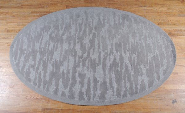 A Modern Wool Tufted Carpet, Edward Fields, 7 feet: A Modern Wool Tufted Carpet, Edward Fields, of oval shape, worked in two shades of gray, the reverse stamped Copyright Edward Fields Inc. 7 feet 11 inches x 5 feet.