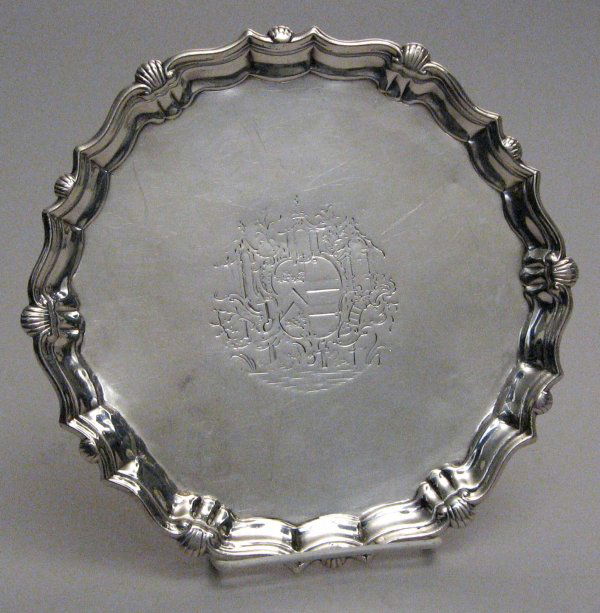George II sterling silver salver, john robinson,: George II sterling silver salver john robinson, london 1743 Of shaped circular form, with a piecrust and shell cast rim, centered by an armorial crest, raised on three scroll feet. Diam: 8 3/4 in. 13