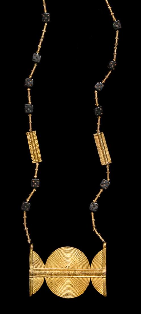 * An Akan Metal Alloy and Glass Dice Bead: * An Akan Metal Alloy and Glass Dice Bead Pendant/Necklace Côte d'Ivoire/Ghana strung with 12 glass dice beads, numerous metal alloy tubular beads and a central rectangular metal alloy rectangular pe