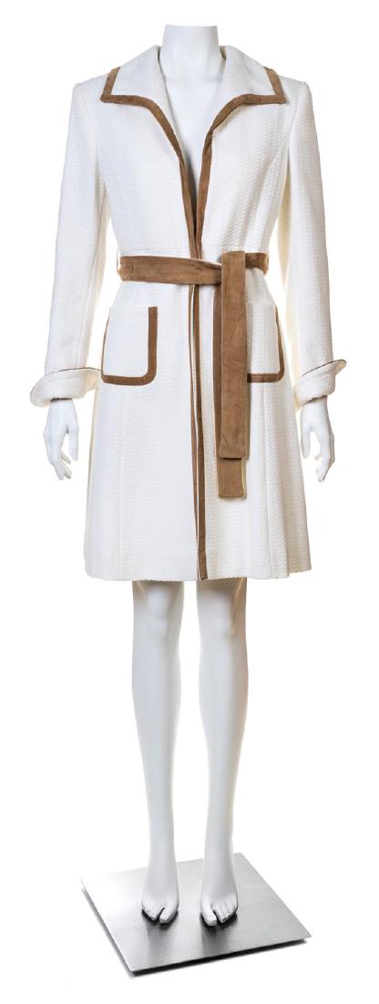 A Valentino Roma White Cotton Coat,: A Valentino Roma White Cotton Coat, with long vented sleeves, a spread collar, camel trim, patch pockets at the hip, a single front center hook closure and a reversible self tie belt. Labeled: Valenti