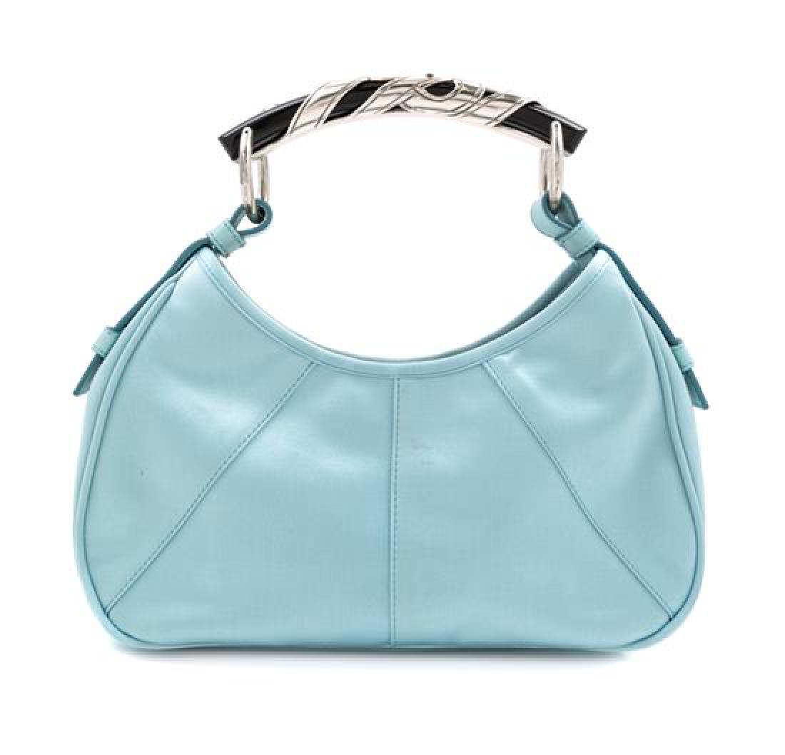 A Tom Ford for Yves Saint Laurent Blue Satin Mombasa: A Tom Ford for Yves Saint Laurent Blue Satin Mombasa Bag, with a black enamel handle with silver embellishment, an interior top magnetic snap closure, black silk lining and an interior slip pocket. St