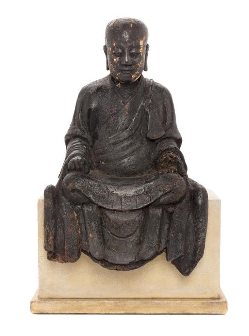 A Chinese Lacquered Wood Figure of a Luohan Height 13: A Chinese Lacquered Wood Figure of a Luohan late ming dynasty the figure depicted seated in the posture of meditation with both hands resting on his laps, wearing long draped robes, the face having a