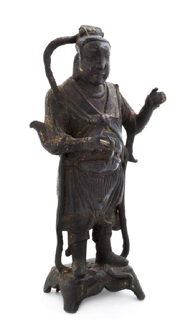A Chinese Bronze Figure of an Immortal Height 11 3/4: A Chinese Bronze Figure of an Immortal the figure standing on a raised pedestal, dressed in draped robes with both hands raised, the round face with a calm expression underneath a tall hat. Height 11