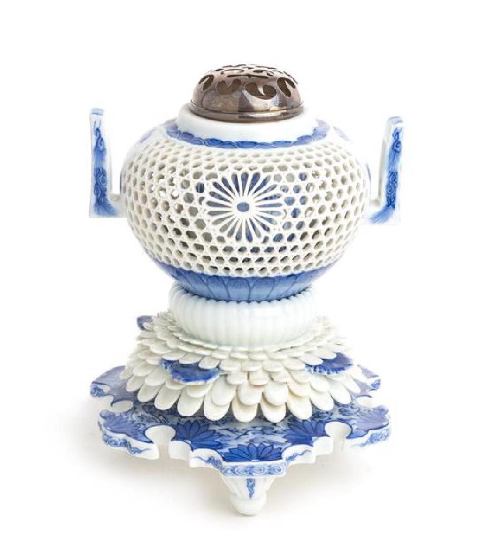A Japanese Blue and White Porcelain Reticulated Incense: A Japanese Blue and White Porcelain Reticulated Incense Burner, Hirado 19th century the globular body having reticulated shaped panels alternating butterflies, the inner central cylinder painted with 