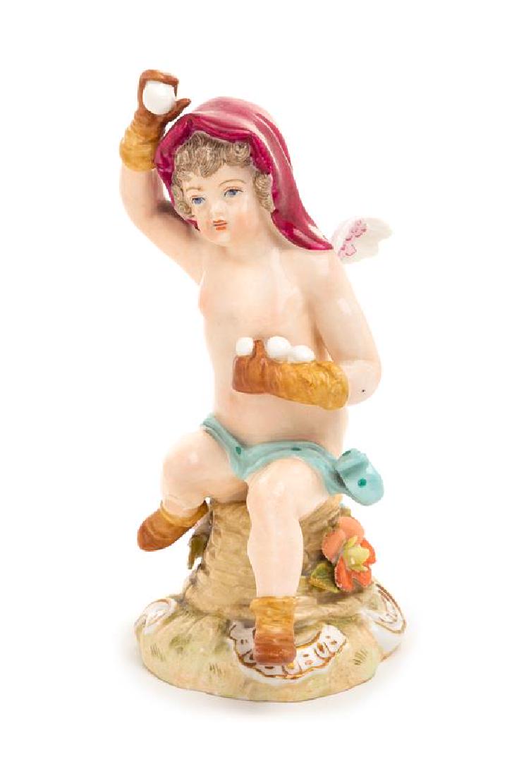 * A Carl Thieme Porcelain Figure Height 5 1/2 inches.: * A Carl Thieme Porcelain Figure late 19th/early 20th century modeled to show Cupid with gloves and snowballs, with crossed T mark in underglaze blue to the underside. Height 5 1/2 inches. Estimate $3