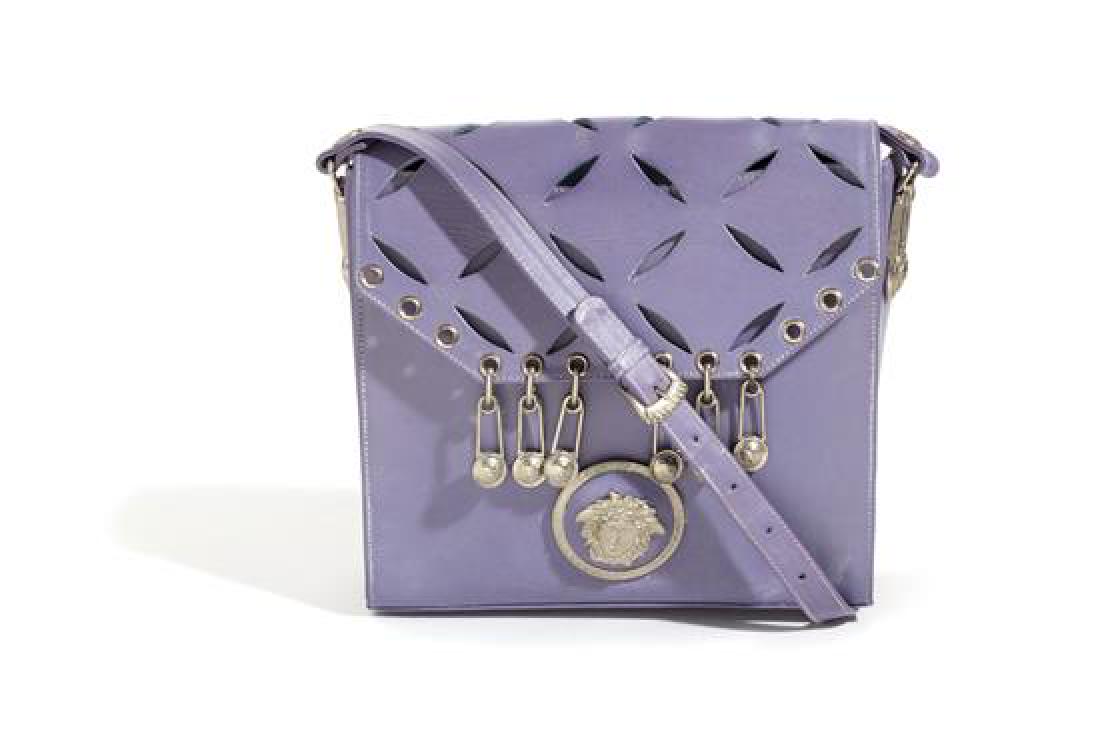A Gianni Versace Purple Leather Safety Pin Shoulder: A Gianni Versace Purple Leather Safety Pin Shoulder Bag, Spring/Summer 1994, with silvertone hardware, a decorative cut out pattern on the front flap, magnetic snap closure, grommet, safety pin and Me