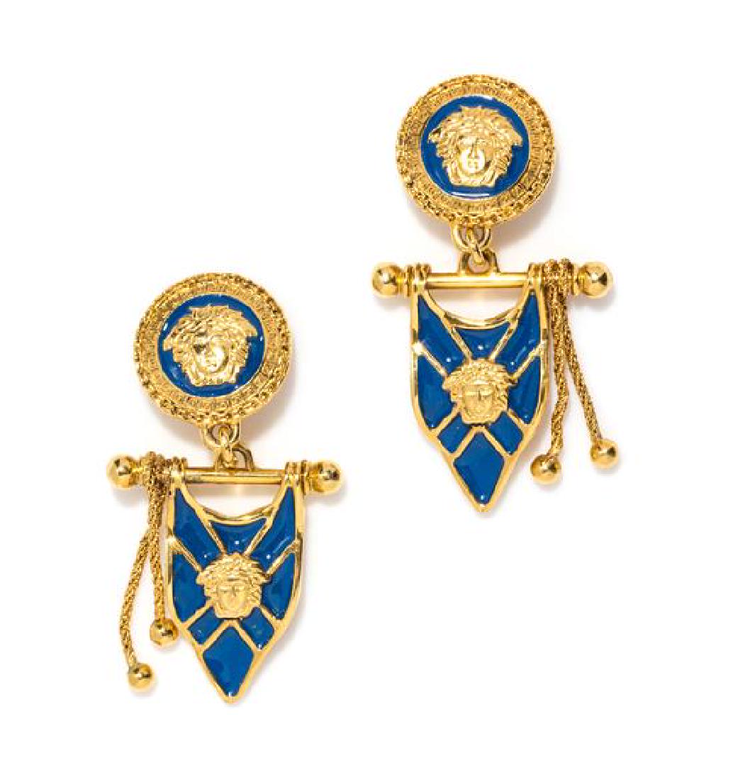 A Pair of Gianni Versace Blue Enamel Flag Drop: A Pair of Gianni Versace Blue Enamel Flag Drop Earclips, Autumn/Winter 1992-1993, goldtone. Design featured in the Fall 1992 ad campaign. Unstamped and attributed to: Gianni Versace. 3.25" x 1.75". Es