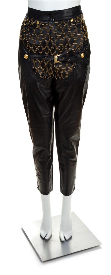A Gianni Versace Black Leather Bondage Pant,: A Gianni Versace Black Leather Bondage Pant, Autumn/Winter 1992-1993, with goldtone hardware, a decorative grommet embellished diamond pattern on the front, front zip closure and half belt and back zi