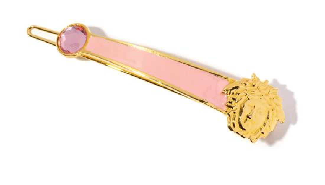 A Gianni Versace Pink Enamel and Medusa Hair Clip,: A Gianni Versace Pink Enamel and Medusa Hair Clip, 1990s, goldtone with a large pink rhinestone embellishment. Stamped: Gianni Versace. 3.25" x .75". Estimate $80-120 Property from a Single-Owner Coll