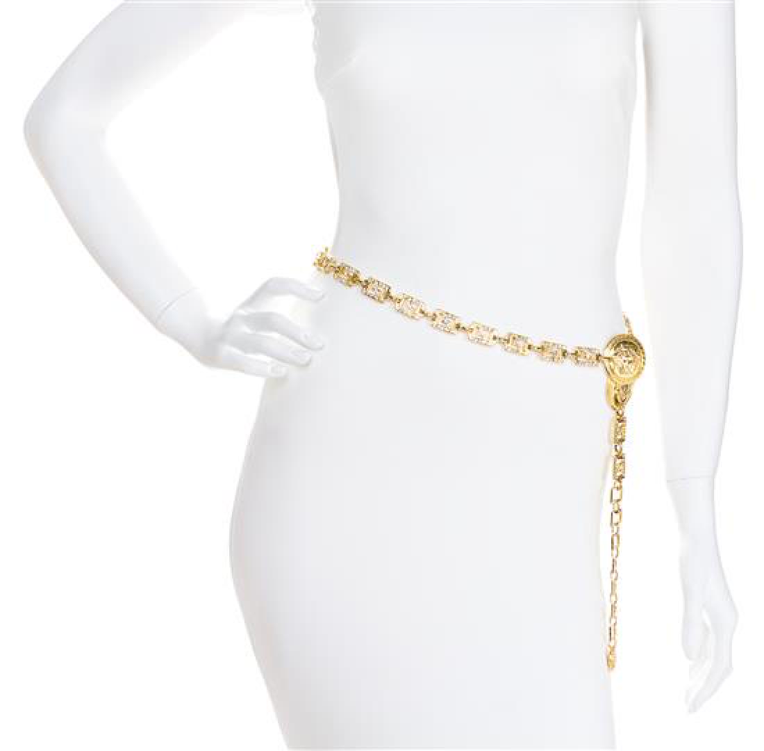 A Gianni Versace Rhinestone Greco Link Belt,: A Gianni Versace Rhinestone Greco Link Belt, 1990s, goldtone with an embossed Medusa disc embellishment at the adjustable hook closure. Stamped: Gianni Versace. Estimate $500-700 Property from a Singl