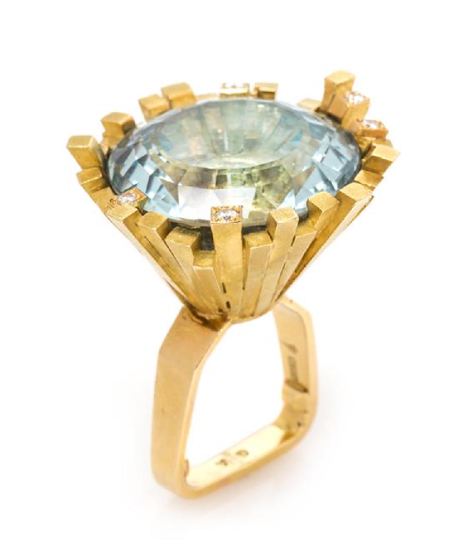 An 18 Karat Yellow Gold, Blue Topaz and Diamond Ring,: An 18 Karat Yellow Gold, Blue Topaz and Diamond Ring, Andrew Grima, Circa 1969, consisting of an upturned cone shape containing one round mixed cut blue topaz measuring approximately 23.45 mm in diame