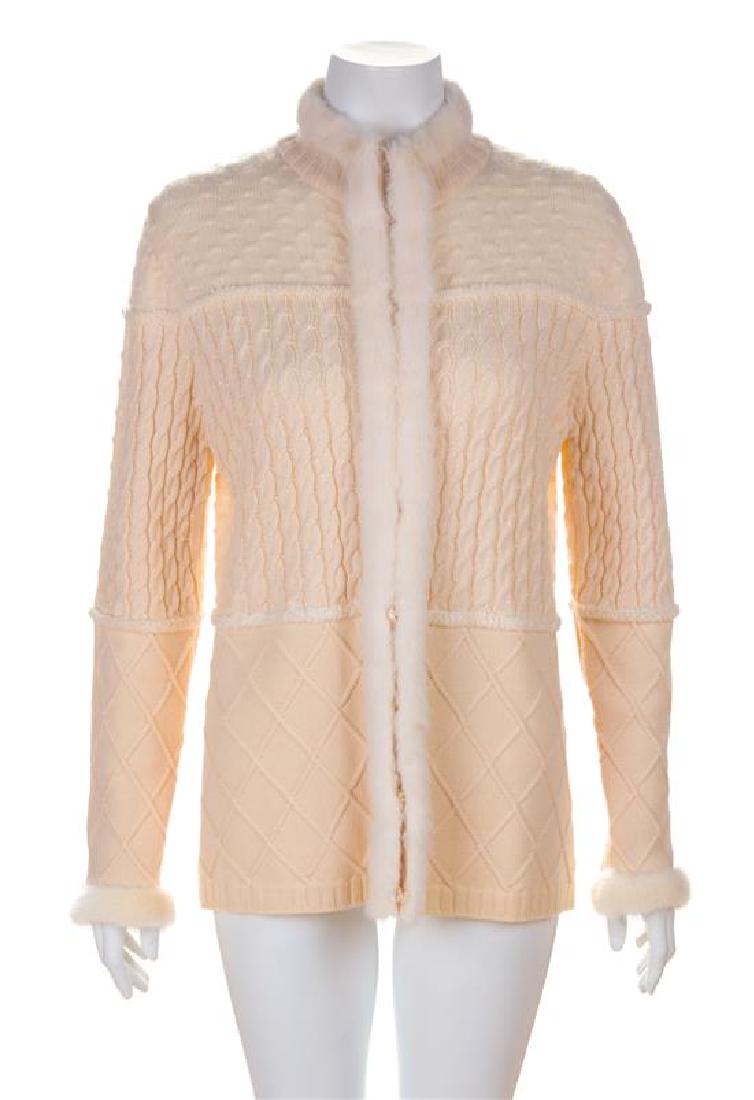 An Escada Cream Wool Cardigan with Fur Trim, Size 38.: An Escada Cream Wool Cardigan with Fur Trim, with a high collar, a cable knit mid-section and hidden front interior button closure. Labeled: Escada. Size 38. Estimate $100-150 Overall very good condit