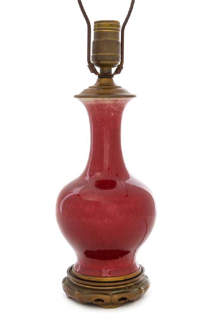 * A Chinese Sang-de-Boeuf Glazed Porcelain Vase Height: * A Chinese Sang-de-Boeuf Glazed Porcelain Vase 18th/19th century the ovoid body raised on a spreading foot, surmounted by a tall neck and an everted mouth, mounted as a lamp. Height of vase 9 inches.