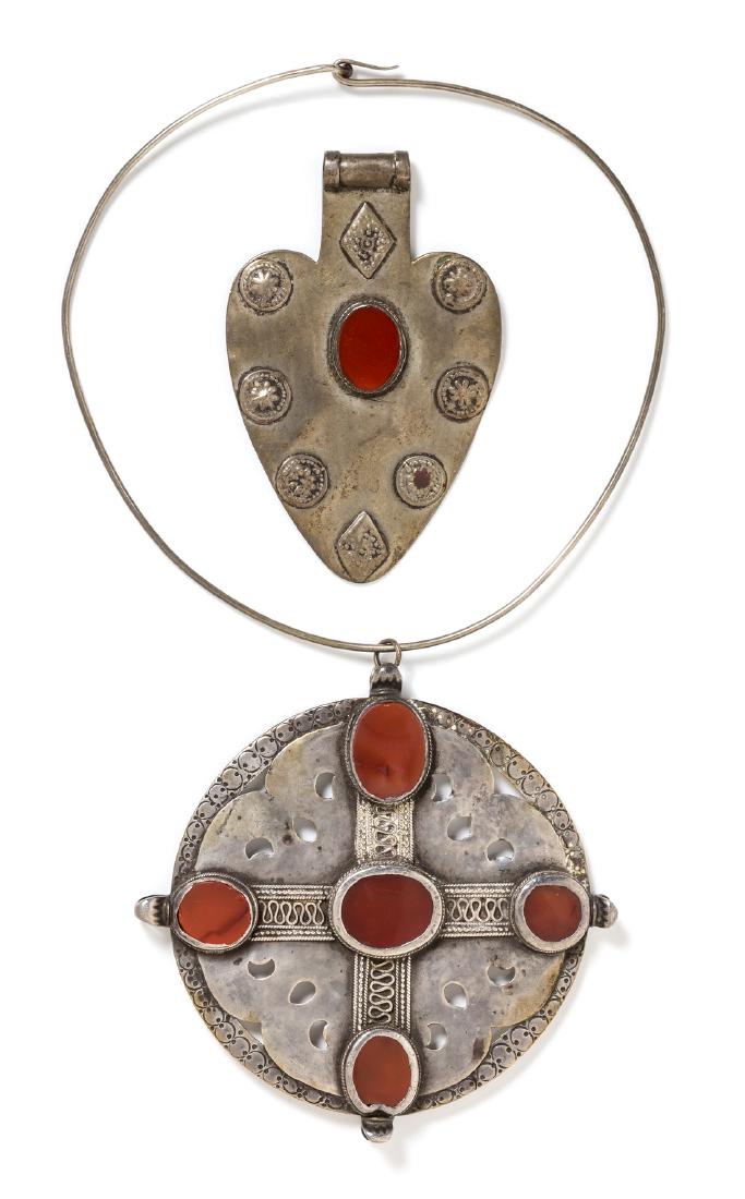 A Collection of Silver and Carnelian Pendants,: A Collection of Silver and Carnelian Pendants, Turkmenistan, consisting of a spade shape pendant measuring approximately 109.00 mm long and mounted with one oval carnelian plaque, together with a coll