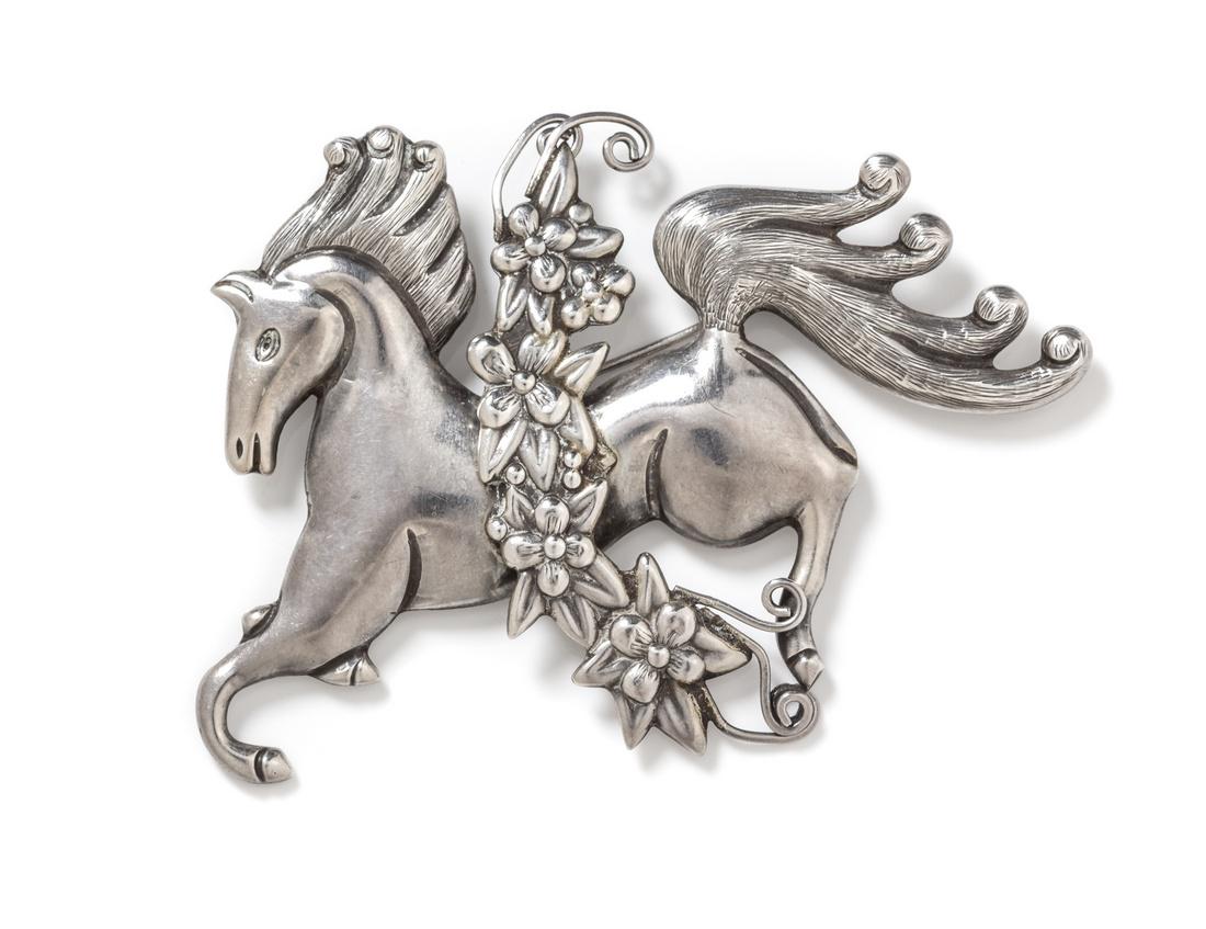 A Sterling Silver Horse Brooch, Los Castillo: A Sterling Silver Horse Brooch, Los Castillo, consisting of a horse with flowing mane and floral overlay. Stamp: LOS CASTILLO TAXCO STERLING MADE IN MEXICO 667. 26.30 dwts.