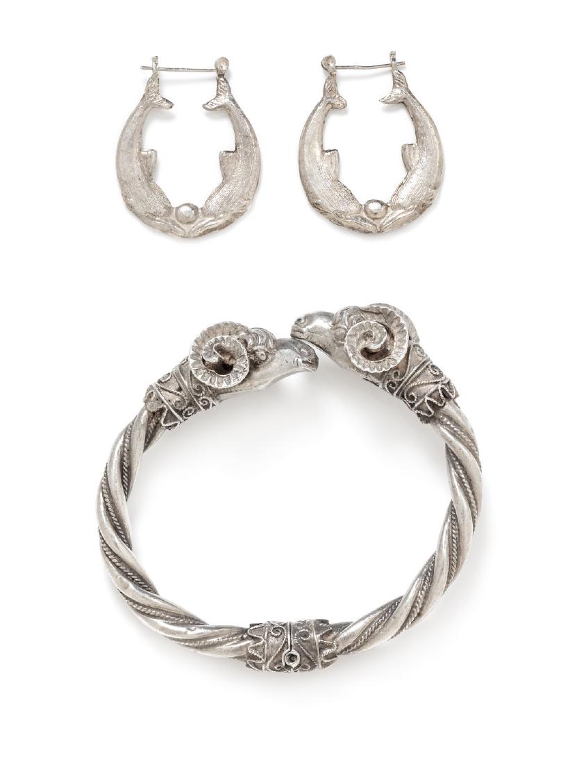 *A Collection of Silver Jewelry: A Collection of Silver Jewelry, consisting of a bangle bracelet with a twisted textured design and accented with ram's head finials, together with a dolphin motif hoop earrings. Bracelet stamp: 925 M3