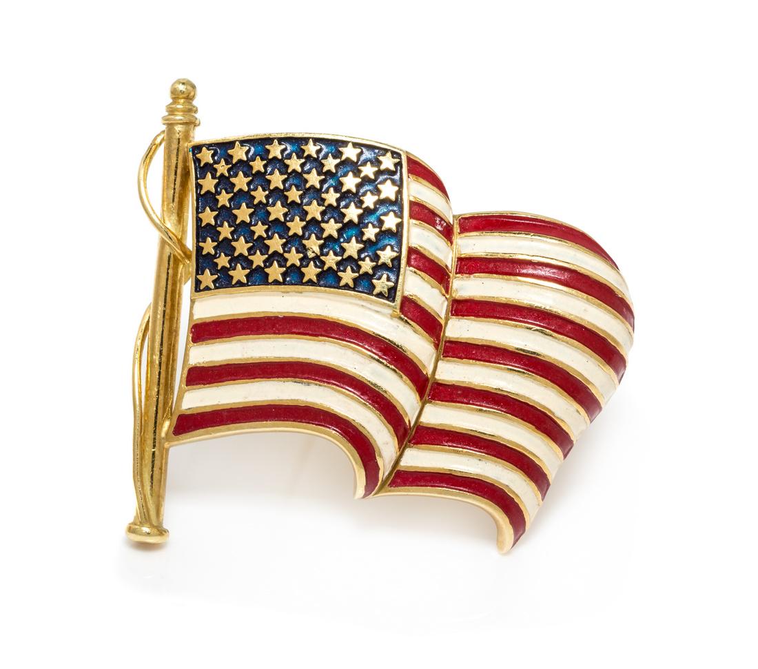 An 18 Karat Yellow Gold and Polychrome Enamel American: An 18 Karat Yellow Gold and Polychrome Enamel American Flag Brooch, consisting of a billowing design with opaque red, white and blue enamel inlay. Engraved: T 18K. 7.30 dwts.