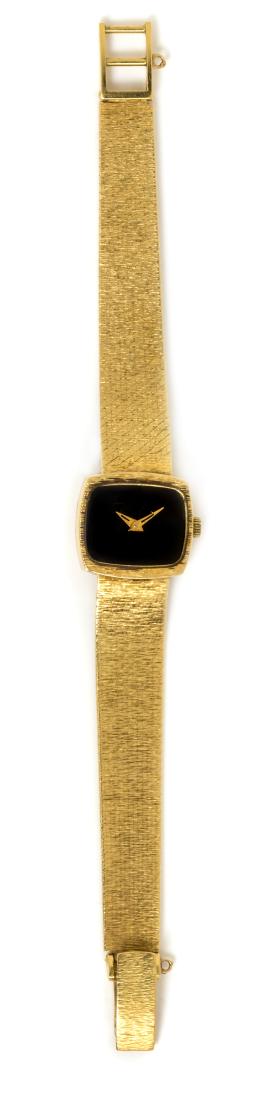 An 18 Karat Yellow Gold Watch, Baume and Mercier, 24.55: An 18 Karat Yellow Gold Watch, Baume and Mercier, 19.00 x 18.00 mm case dimensions, black dial, gold dauphine hands, cushion shaped case, snap on case back, quartz movement, integrated textured mesh l