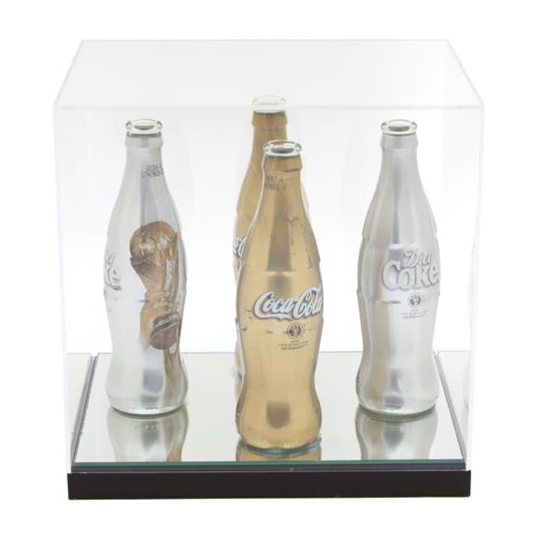 Artist Unknown, (20th Century), Four Coke Cans, World: Artist Unknown (20th Century) Four Coke Cans, World Cup mixed media mounted on mirror Height 8 inches. Estimate $80-120 Property from the Estate of Arnold Scaasi and Parker Ladd, Palm Beach, FL