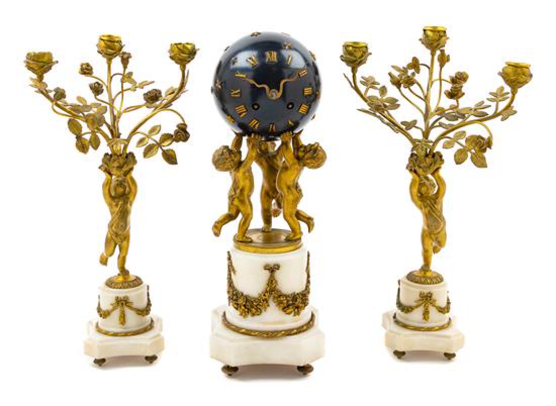 A French Gilt Bronze and Marble Globe Clock Garniture: A French Gilt Bronze and Marble Globe Clock Garniture jean vincent & cie, late 19th century the case in the form of three putti supporting the spherical dial with Roman numeral hours, set on a cylindr