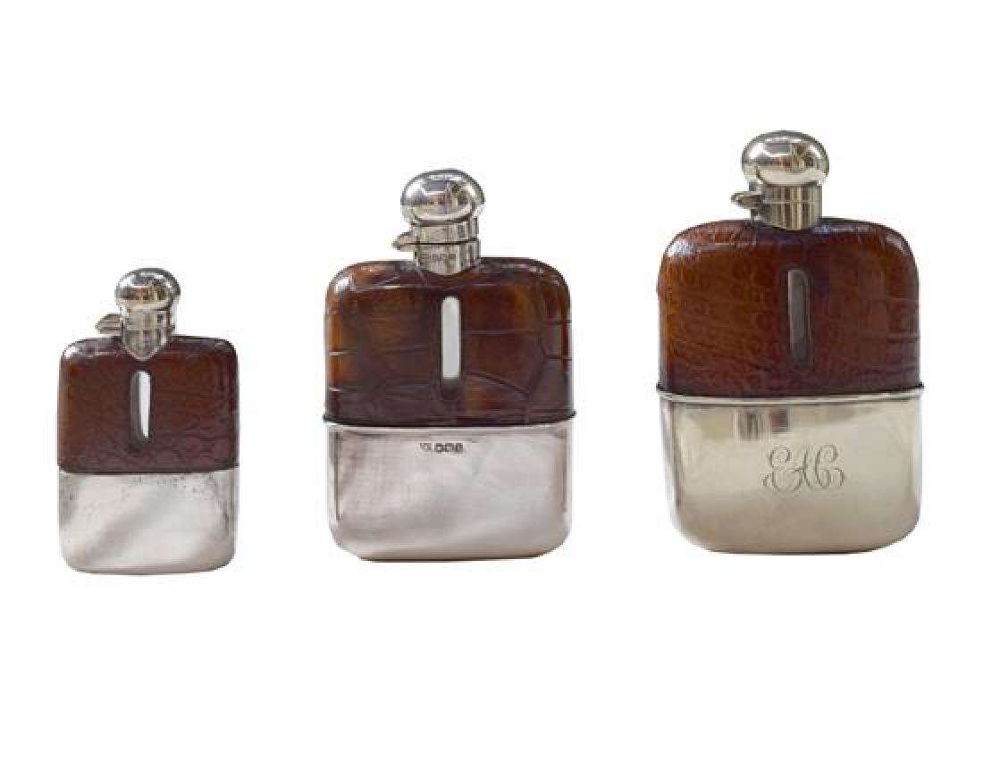 A Set of Three Silver and Stamped Leather Hip Flasks (1 of 7)