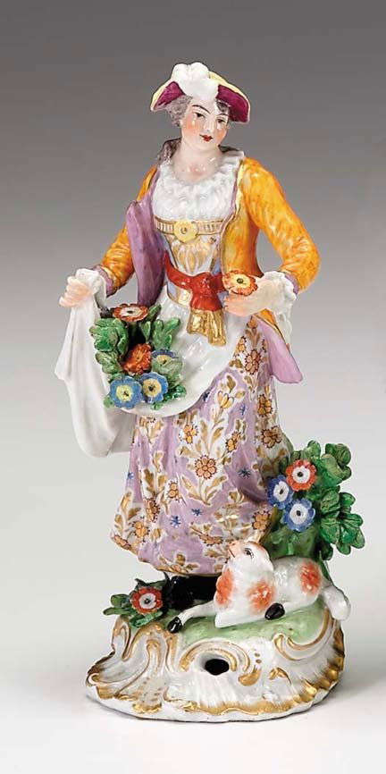 Crown Derby porcelain figure of a shepherdess, 18: Crown Derby porcelain figure of a shepherdess 1800-1825 The standing figure wearing an orange jacket and flower painted lilac dress, applied with flowers and foliage, a lamb resting at her feet, raise