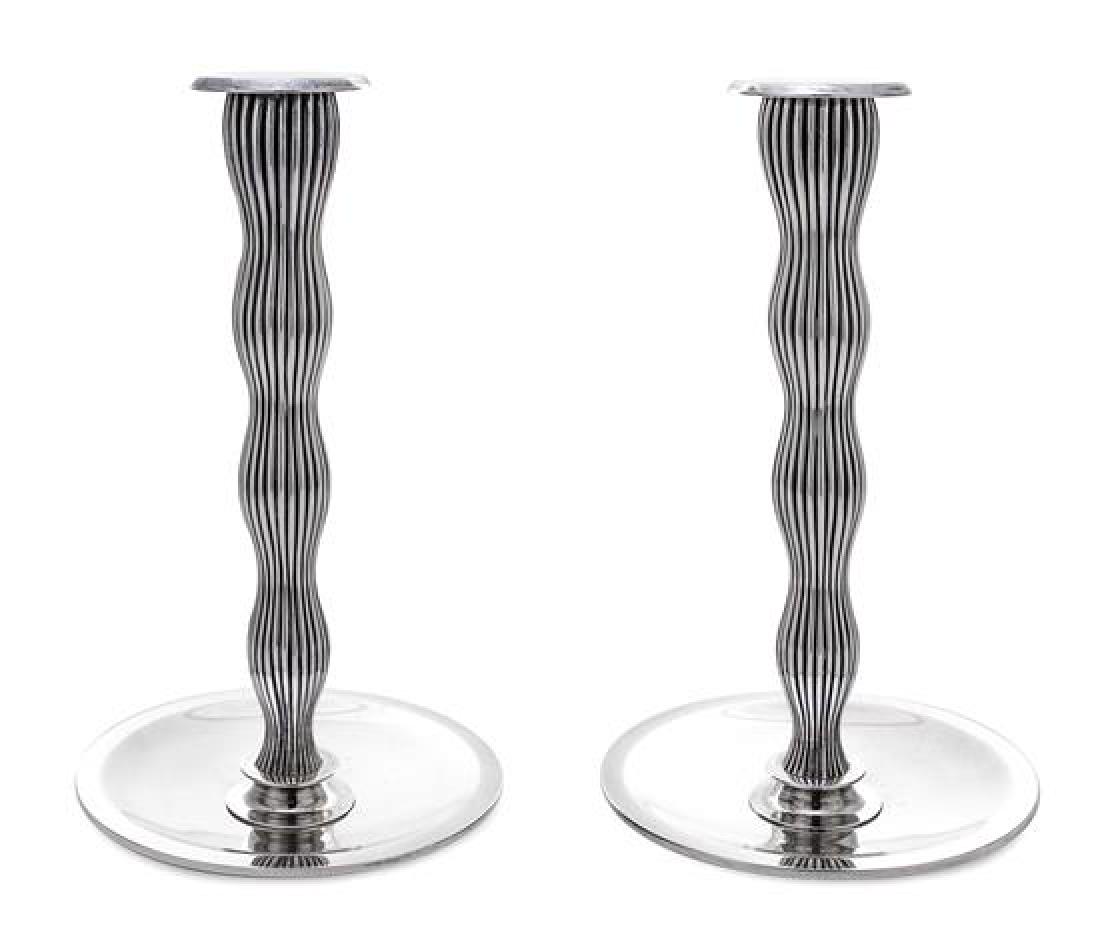 * A Pair of Danish Silver Candlesticks, Designed by: * A Pair of Danish Silver Candlesticks Designed by Svend Weihrauch for Frantz Hingelberg, Aarhus, Mid-20th Century of tapered and undulating ribbed cylindrical design, each raised on a circular dish b