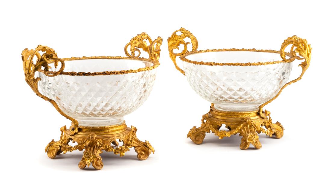 A Pair of French Gilt Bronze Mounted Cut Glass Center: A Pair of French Gilt Bronze Mounted Cut Glass Center Bowls 20th century each of handled form with foliate cast mounts, the glass with diamond cut decoration. Width 16 inches. Estimate $1,000-1,500