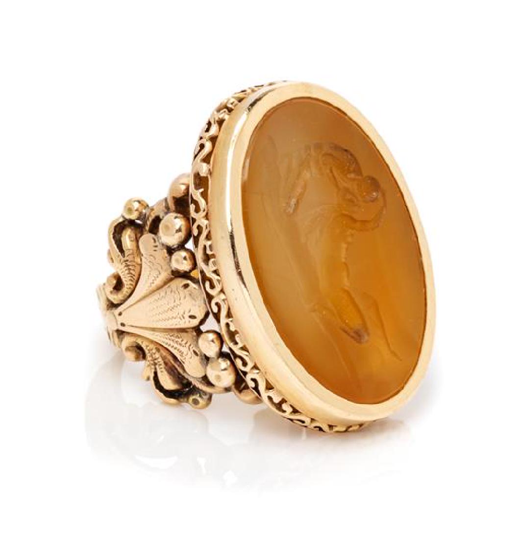 A Victorian Yellow Gold and Agate Intaglio Ring, 12.00: A Victorian Yellow Gold and Agate Intaglio Ring, containing one oval agate intaglio carved with a Classical scene of lovers embracing. 12.00 dwts. Estimate $500-700