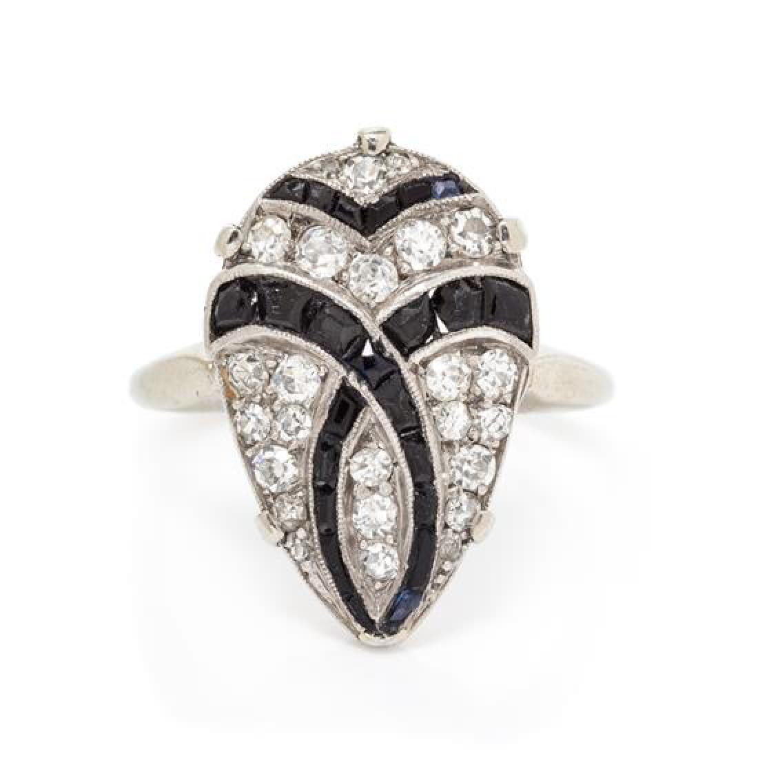An Antique Platinum, White Gold, Diamond and Onyx Ring,: An Antique Platinum, White Gold, Diamond and Onyx Ring, consisting of a pear shaped platinum plaque containing 25 round single and old mine cut diamonds weighing approximately 0.45 carat total and 24 