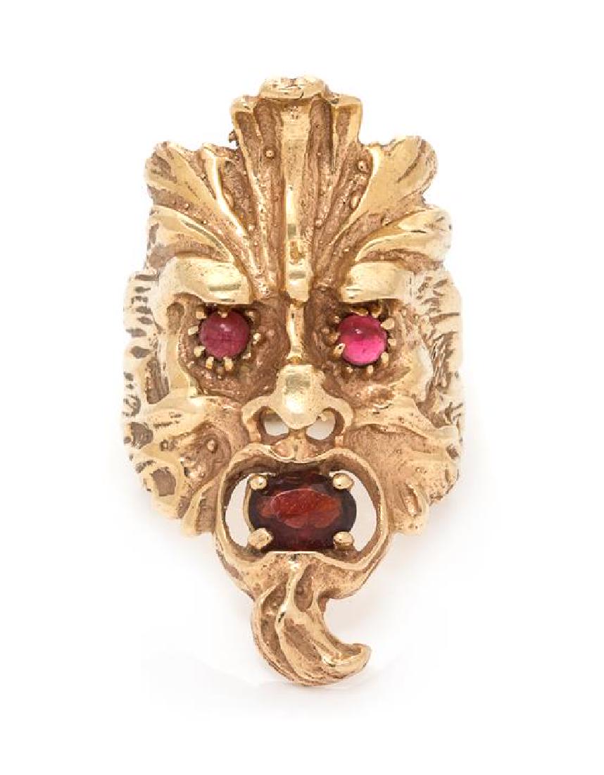 A 14 Karat Rose Gold and Garnet Ring, 9.95 dwts.: A 14 Karat Rose Gold and Garnet Ring, consisting of a foliate designed face containing one oval shape mixed cut garnet measuring approximately 6.65 x 4.50 mm and two round cabochon cut garnet eyes mea