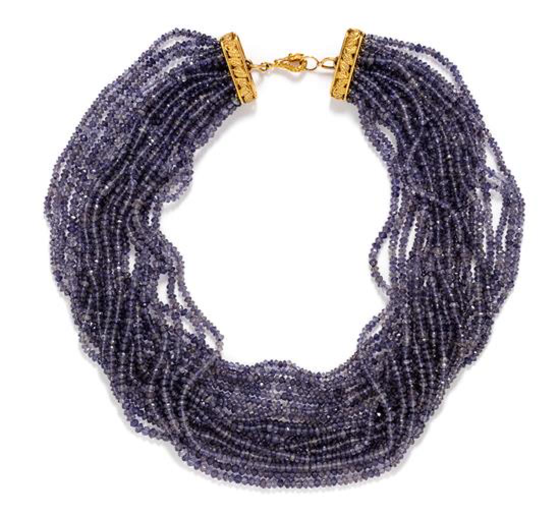 A Yellow Gold and Iolite Torsade Necklace, 78.20 dwts.: A Yellow Gold and Iolite Torsade Necklace, containing 20 strands of faceted iolite beads measuring approximately 3.00-3.40 mm in diameter strung with a yellow gold clasp with a pierced and carved leaf