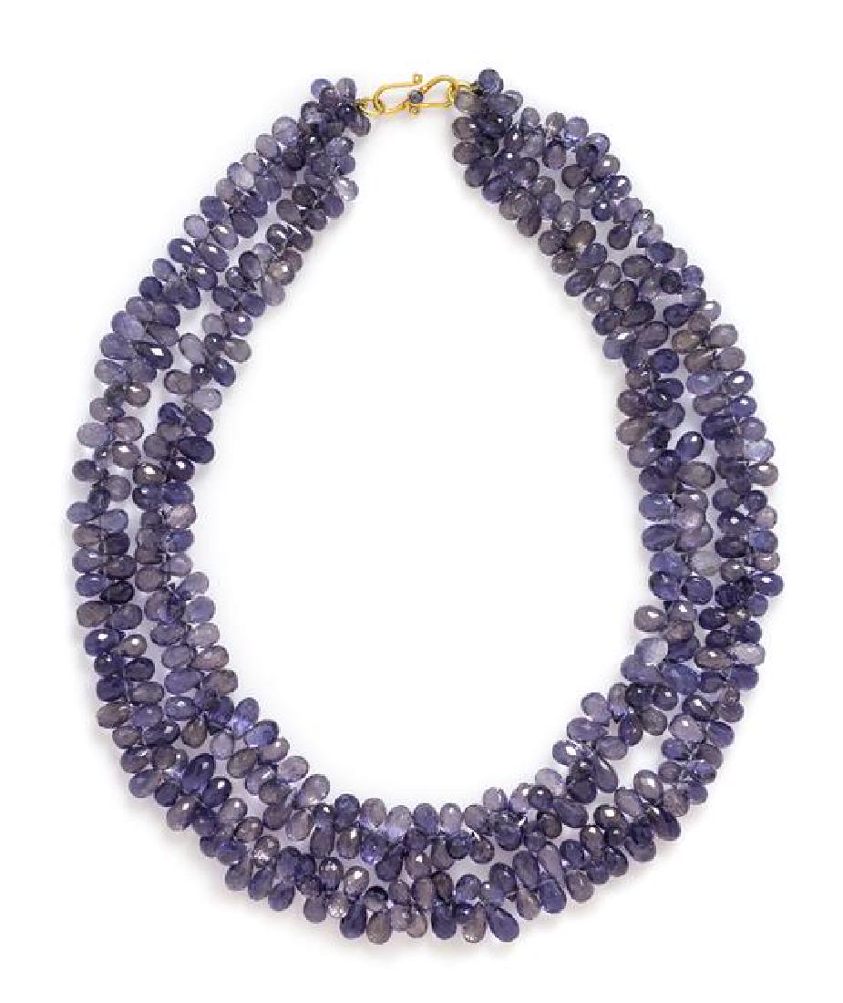 A High Karat Yellow Gold and Iolite Multistrand Bead: A High Karat Yellow Gold and Iolite Multistrand Bead Necklace, consisting of two strands of briolette iolite beads strung knotted with a high karat yellow gold clasp containing one round mixed cut sap