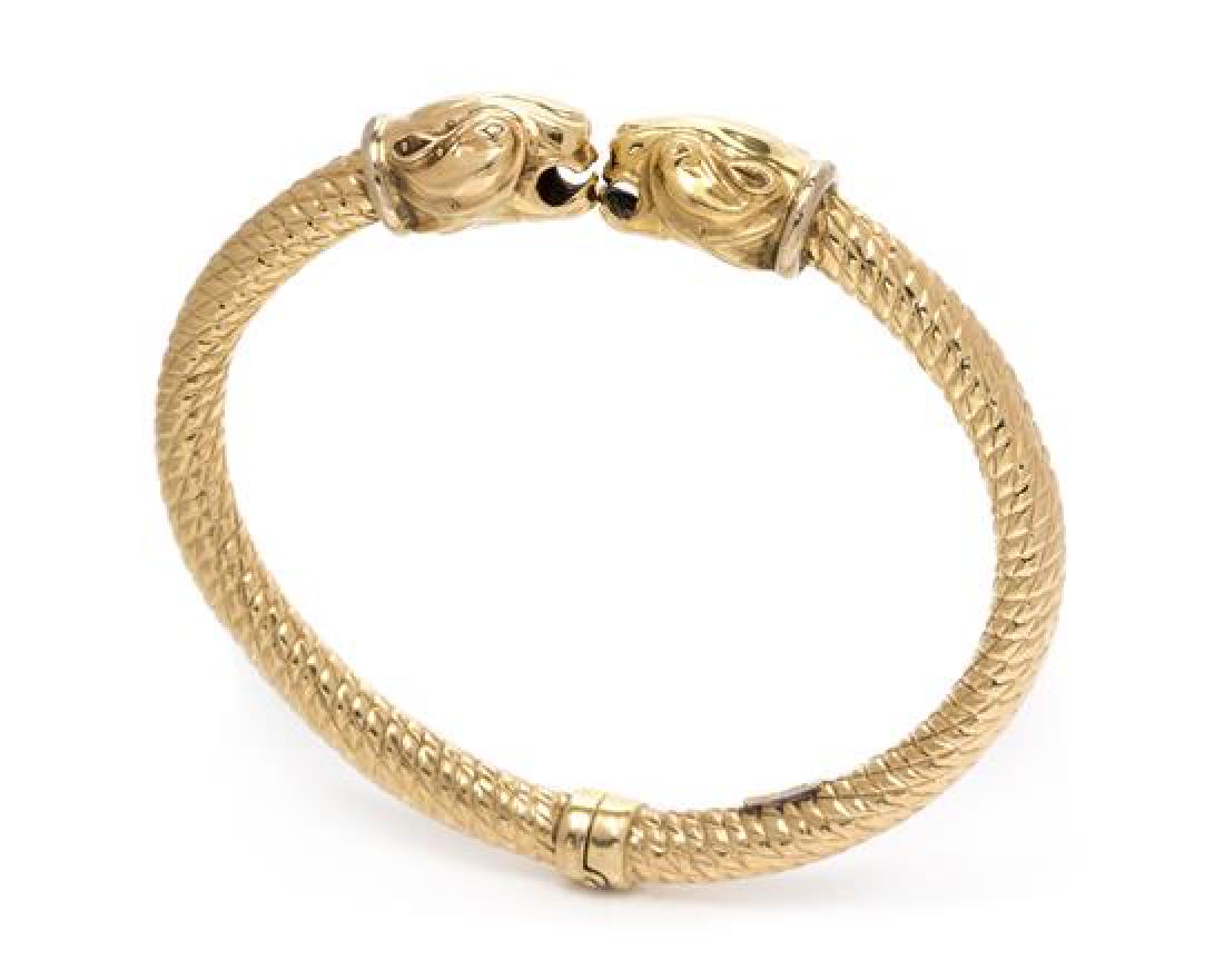 *A 14 Karat Yellow Gold Panther Motif Bangle, Italian,: *A 14 Karat Yellow Gold Panther Motif Bangle, Italian, consisting of a twisted textured bangle with opposing panther head finials, hinged at the base. Stamp: 14KT ITALY Fancy. 13.40 dwts. Estimate $30