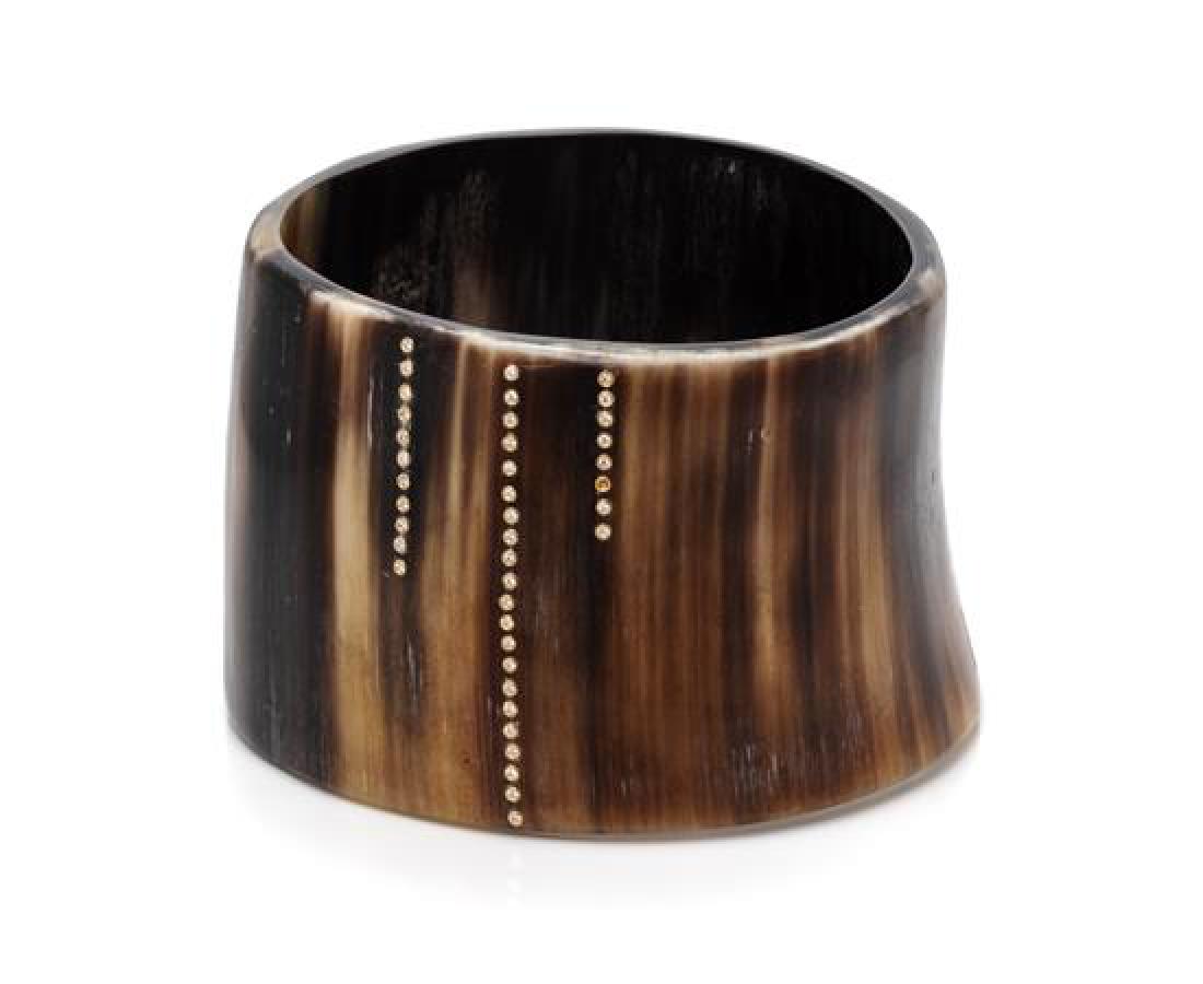 A Buffalo Horn, Yellow Gold and Diamond Bangle: A Buffalo Horn, Yellow Gold and Diamond Bangle Bracelet, Monique Péan, containing 45 round brilliant cut diamonds, measuring approximately 46.00 mm wide. Unsigned. 29.10 dwts. Estimate $500-700