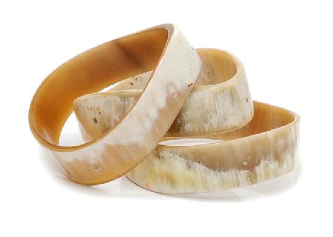 A Collection of Buffalo Horn, White Gold and Diamond: A Collection of Buffalo Horn, White Gold and Diamond 'Wave' Bangle Bracelets, Monique Péan, consisting of three cream buffalo horn wave shaped bangles, containing nine round brilliant cut diamonds to