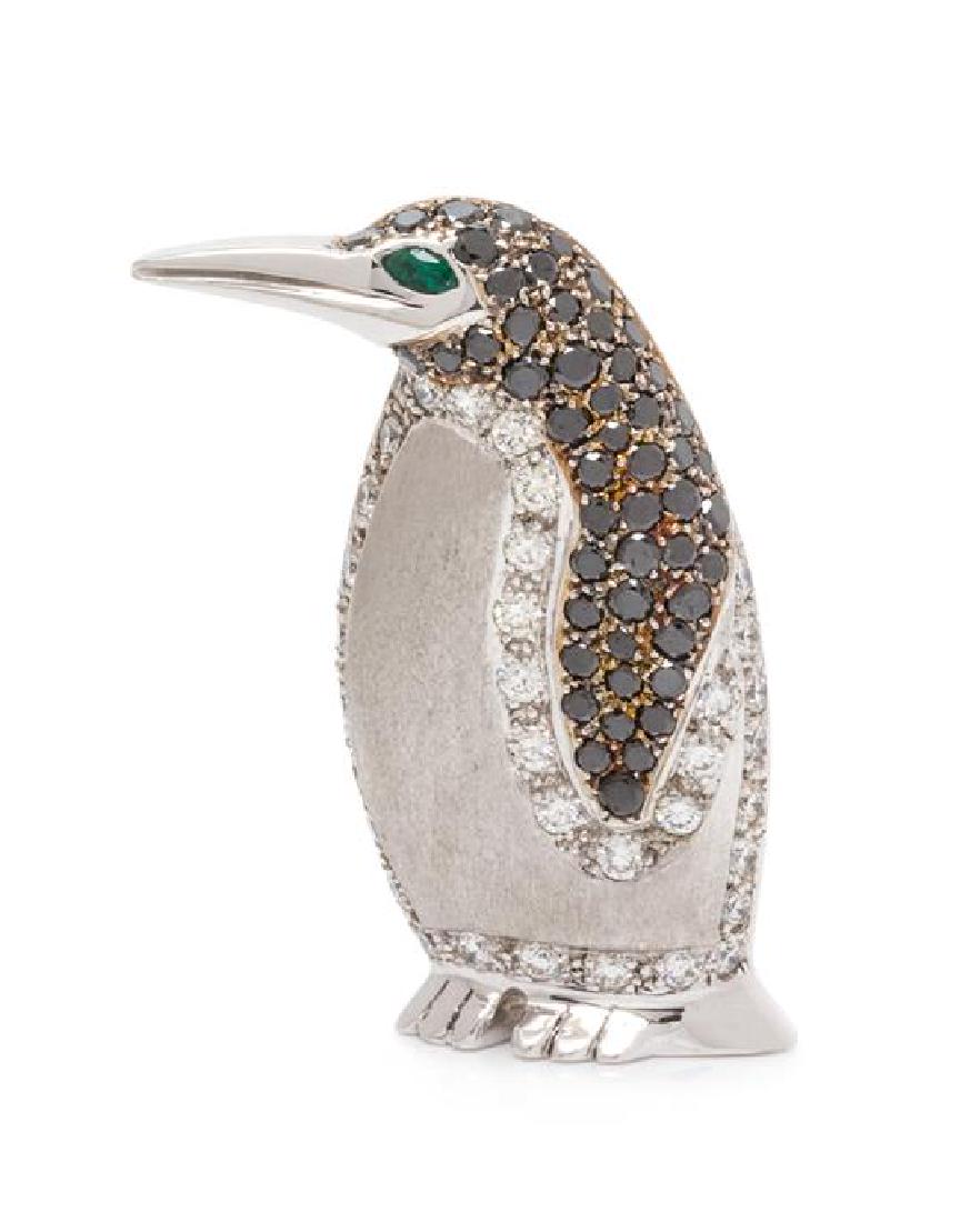 A 14 Karat White Gold, Diamond, Black Diamond and: A 14 Karat White Gold, Diamond, Black Diamond and Emerald Penguin Brooch, Alopa, containing 35 round brilliant cut diamonds weighing approximately 1.40 carats total, 50 round mixed cut black diamonds 
