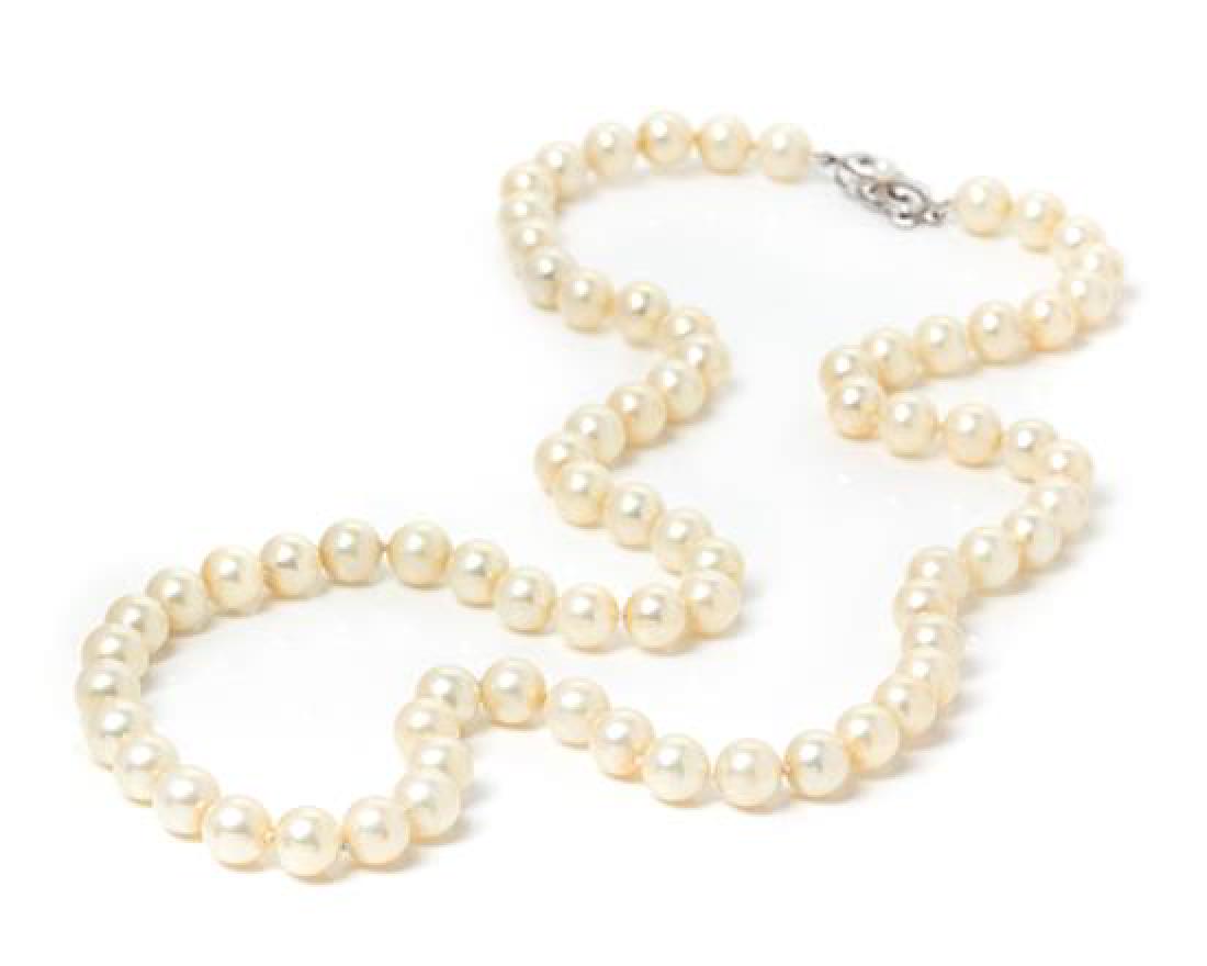 A 14 Karat White Gold and Cultured Pearl Necklace,: A 14 Karat White Gold and Cultured Pearl Necklace, Mikimoto, consisting of 74 pearls measuring approximately 8.35-8.65 mm in diameter strung knotted with a 14 karat white gold clasp surmounted with on