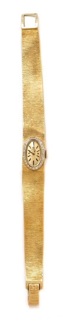 A 14 Karat Yellow Gold and Diamond Wristwatch, Omega,: A 14 Karat Yellow Gold and Diamond Wristwatch, Omega, 14.00 x 18.00 mm case dimensions, bezel containing 28 round single cut diamonds weighing approximately 0.25 carat total, oval gold textured dial s