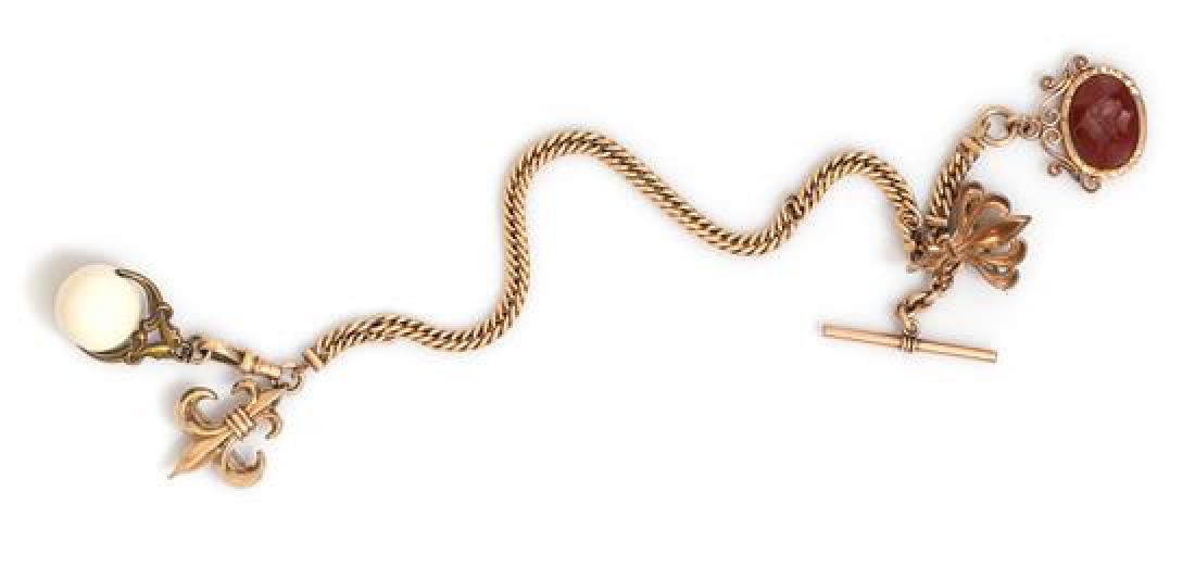 A Gold Filled Watch Fob Chain with Attached Fobs and: A Gold Filled Watch Fob Chain with Attached Fobs and Brooches, consisting of a curb link chain with attached carnelian and white hardstone fobs suspended from fleur-de-lis and filigree motif brooches.
