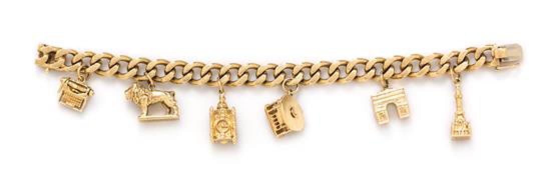 A 14 Karat Yellow Gold Charm Bracelet with Six Attached: A 14 Karat Yellow Gold Charm Bracelet with Six Attached Charms, including a yellow gold typewriter charm, a 14 karat gold Art Institute of Chicago lion charm, a 14 karat gold Marshall Field & Co. cloc