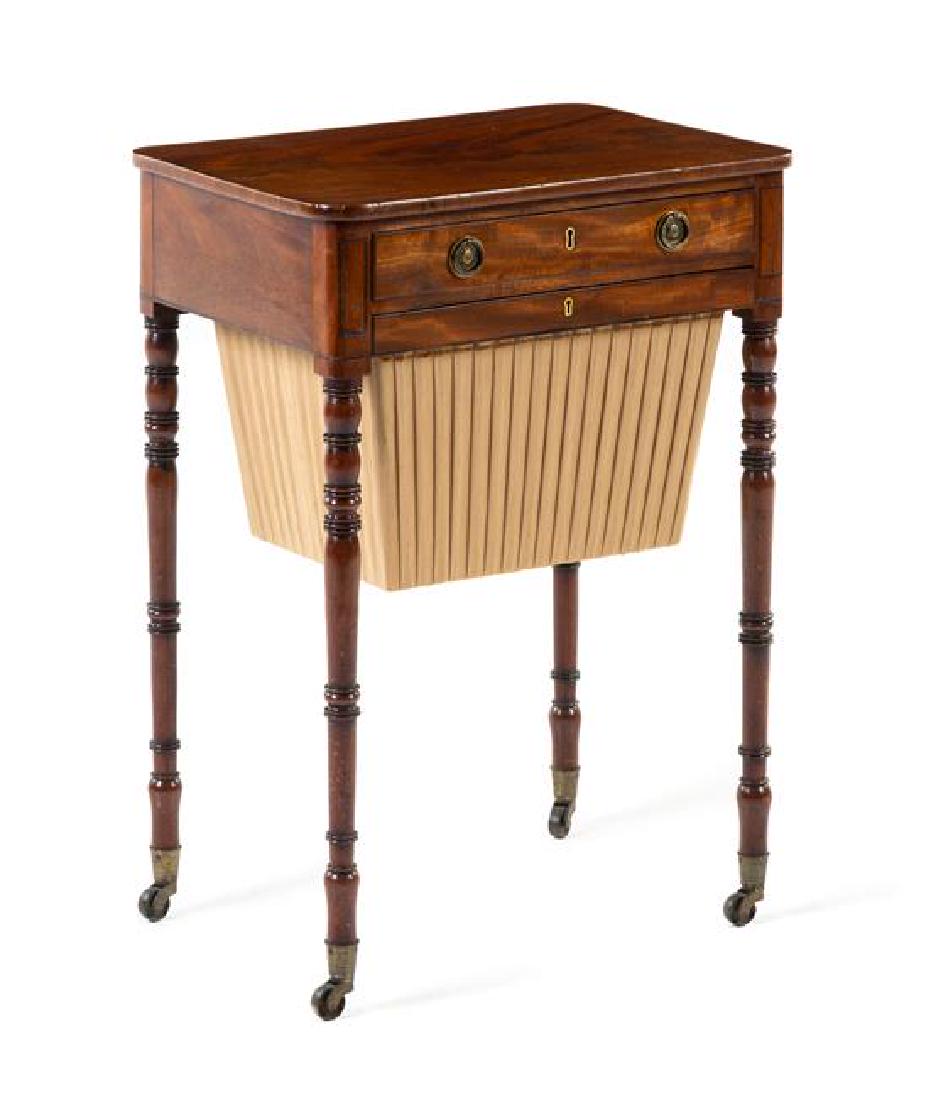 A Sheraton Mahogany Sewing Table Height 28 5/8 x width: A Sheraton Mahogany Sewing Table first half 19th century the rectangular top with rounded corners above the frieze drawer and bag drawer, raised on ring turned cylindrical legs ending in brass caps an