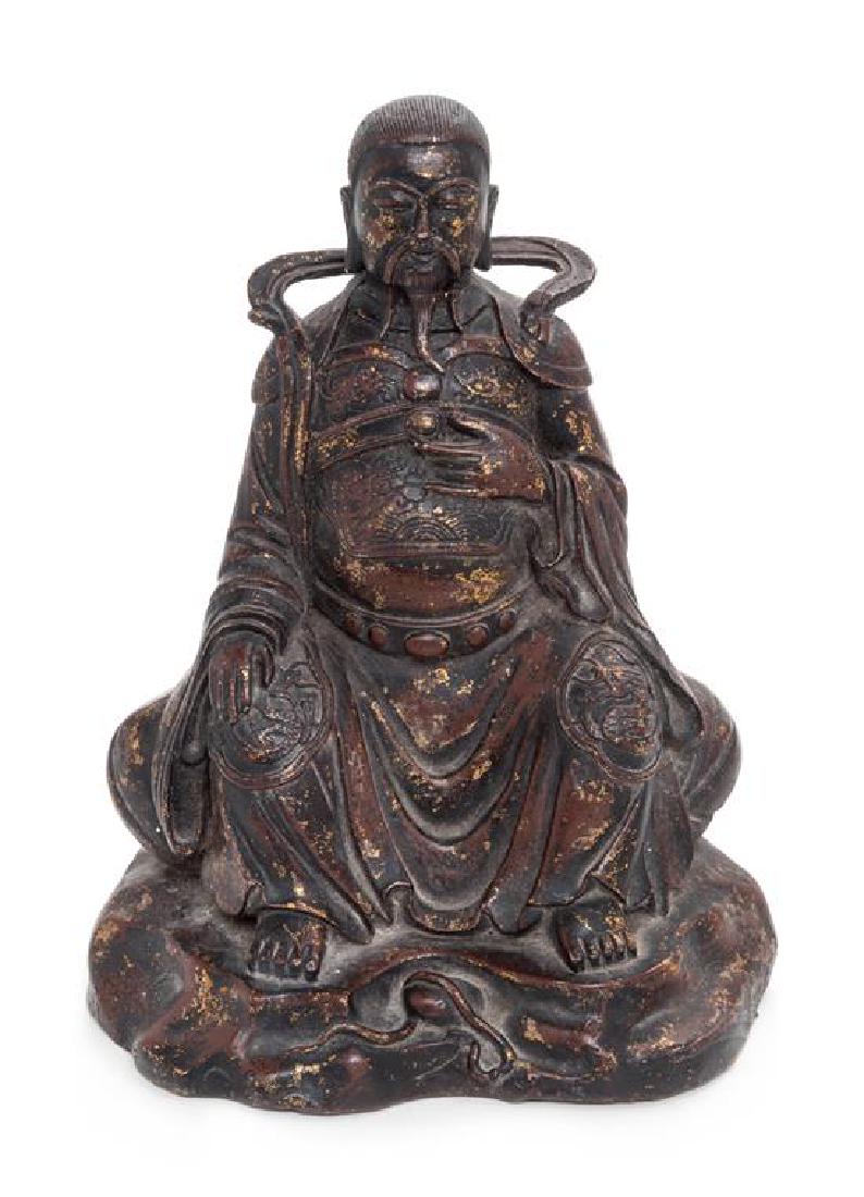 A Gilt Lacquered Bronze Figure of a Daoist Immortal,: A Gilt Lacquered Bronze Figure of a Daoist Immortal, Zhen Wu ming dynasty (1368-1644) the figure depicted seated with his left hand raised at front and the right hand placed on the right knee, dressed