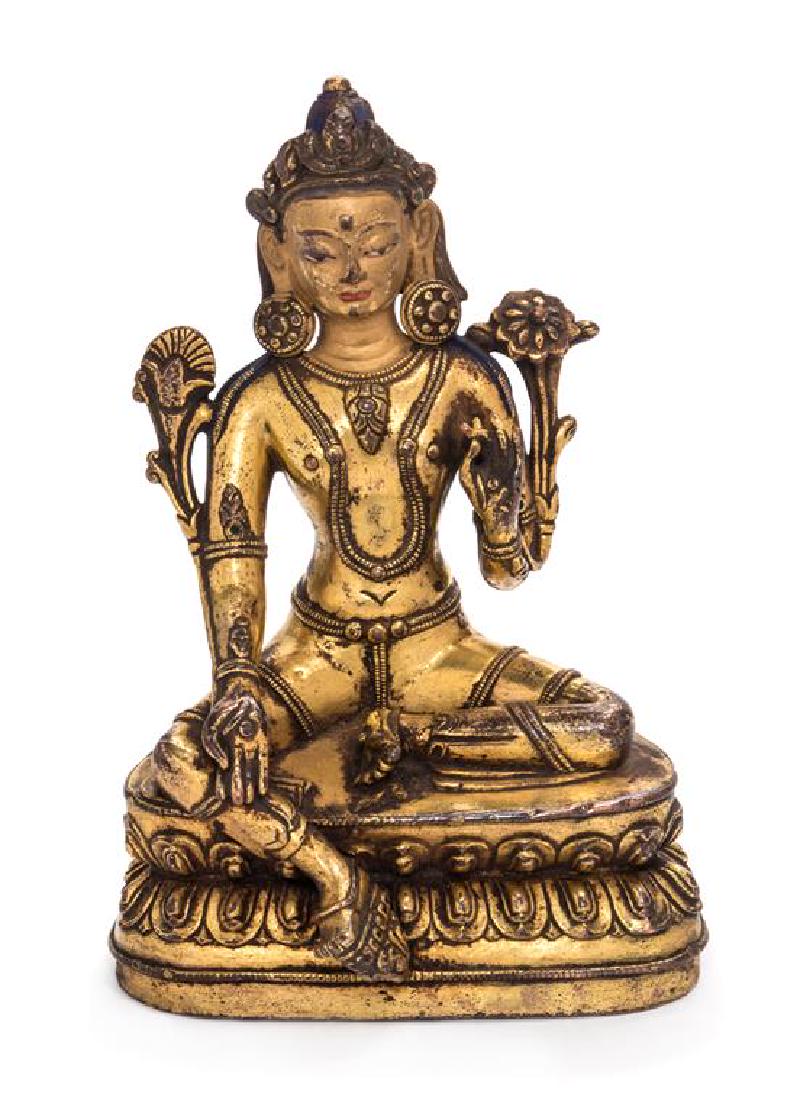 A Sino-Tibetan Gilt Bronze Figure of Green Tara Height: A Sino-Tibetan Gilt Bronze Figure of Green Tara 17th/18th century cast seated in lalitasana on a double lotus base with right hand lowered in varadamudra and left arm raised in vitarkamudra, dressed i