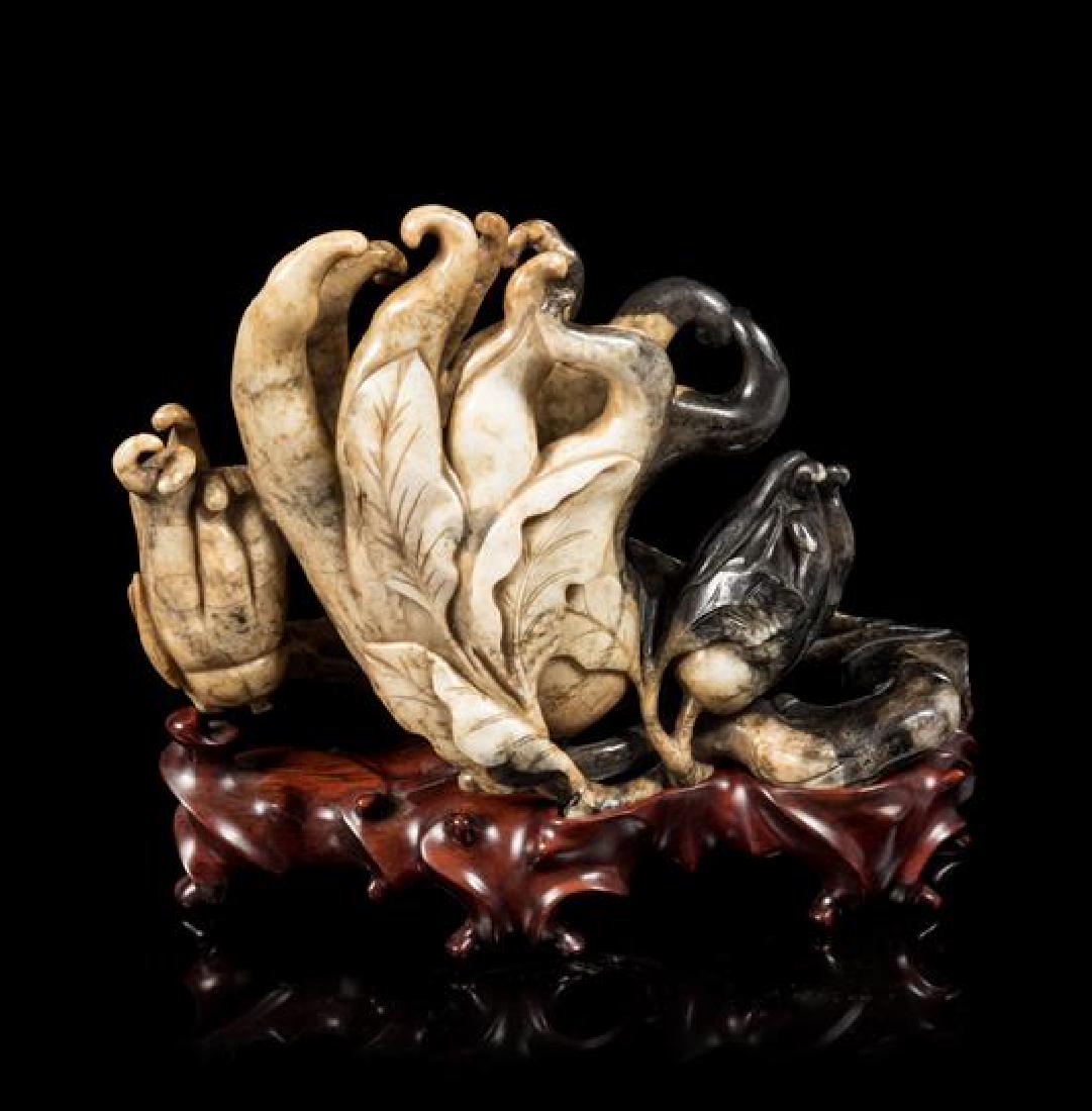 * A Chicken Bone and Black Jade Carving of a Buddha's: * A Chicken Bone and Black Jade Carving of a Buddha's Hand Cirtrons 18th century depicting three finger cirtrons borne on a leafy vine, raised on a fitted rosewood stand. Length 9 inches. Estimate $2,