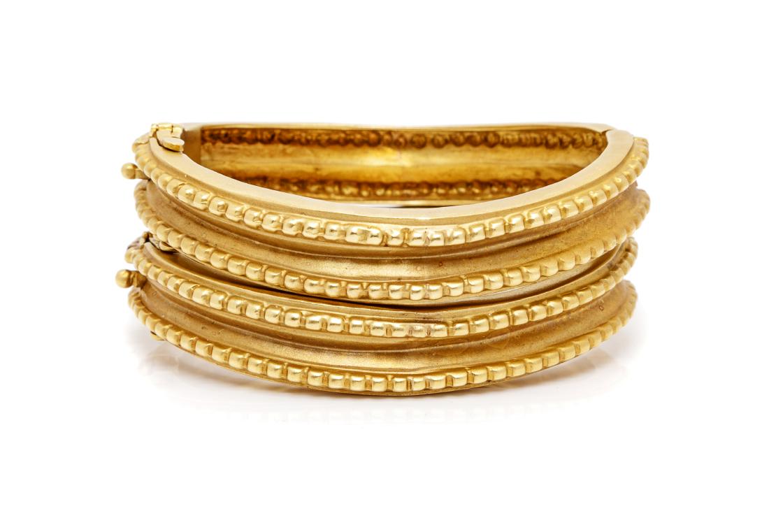 * A Pair of 18 Karat Yellow Gold Bangle Bracelets,: * A Pair of 18 Karat Yellow Gold Bangle Bracelets, consisting of a curvilinear design with beaded edge and matte finish, side hinge and clasp. Stamp: 18K. 64.20 dwts. Estimate $2,000-3,000 Property fr